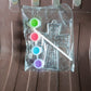 Assorted acrylic paint tubes and a plastic stencil for creative projects.