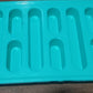 The ice tray placed next to a glass of water with ice, highlighting its practical use.