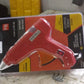 Packaging for the professional hot melt glue gun, indicating its power and contents.