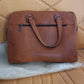 Side view of tan faux leather laptop messenger bag with shoulder strap