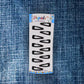 A single matt black Metal Tic Tac Hair Clip demonstrating its strong, flexible mechanism.