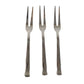 Three small appetizer forks laid out for serving snacks