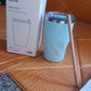 Portable stainless steel insulated coffee mug with wooden straw, ideal for travel