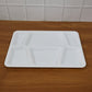 Rectangular sectioned plastic tray with spill-proof raised edges for tidy meal presentation.