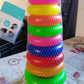 Happy baby playing with the colorful teddy bear stacking rings toy.