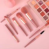 An 8-piece mini makeup brush set with a light pink handle and synthetic bristles, arranged neatly.