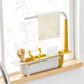 The adjustable sink organizer neatly holding a dish soap bottle, sponge, and scrub brush.