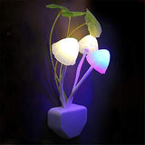 A vibrant LED mushroom night light plugged into a wall socket.