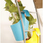 Assorted plastic hanging planter pots in a garden setting.