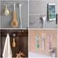 A transparent wall hook securely holding a coat and a towel in a modern hallway.