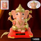 Solar Ganesha idol figurine enclosed in a transparent protective box with vibrant base