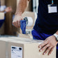 Hand holding a roll of strong adhesive transparent packing tape.