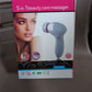 Lifestyle shot of the VelvaBloom pink facial massager in a bathroom setting.
