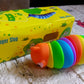 Simple studio shot of a rainbow plastic slug fidget toy against a clean white backdrop.
