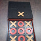 Lifestyle image of the X & Zero wooden board game, ready for play on a table, suggesting family fun.
