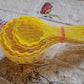 A perfectly shaped ladoo sits next to the plastic mould spoon used to create it.