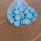Classic white glass marbles with colorful swirls displayed for gaming and decor