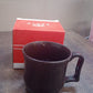 Retail packaging for the black plastic coffee mug, featuring a vibrant color box.