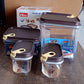 Set of four clear airtight food containers on a kitchen counter.