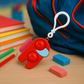 A Pop-It Fidget Keychain hanging from a backpack, illustrating its convenient clip-on design for travel.