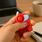 Hand holding a vibrant Pop-It Fidget Keychain, demonstrating its portable size and easy popping action.