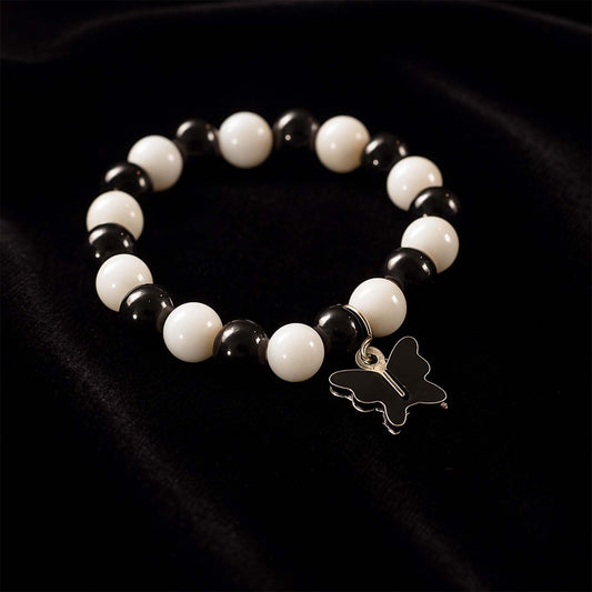 Close-up of black and white beads and cross pendant on bracelet