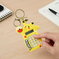 Cartoon keychain calculator with bright yellow character and metal ring bell charm