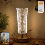 Crystal table lamp with sparkle acrylic shade and golden base illuminating softly