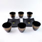 Stack of ceramic bowls and cups from the 8-piece collection by Indo Glow.