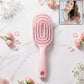Pink curved vented detangling hair brush designed for effortless hairstyling