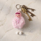 Close-up of plush doll's sleeping face and attached soft fur ball on keychain