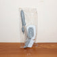 Soap-dispensing dish brush in action, cleaning food residue from a plate