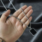 Black rectangular pendant framed in polished metal on men's stainless-steel chain