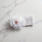 Floral baby headband displayed on a white background, highlighting soft elastic material and floral bow