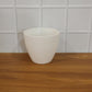 Live plant growing healthily in a white ribbed flower pot