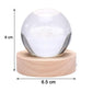 Hand holding the crystal ball lamp to show its compact size and portability.