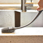 A bottle cleaning brush with a long handle, ideal for reaching the bottom of tall containers.