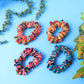 Close-up of assorted printed fabric hair scrunchies showing vibrant patterns