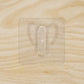 Close-up of transparent wall hook showing its adhesive pad
