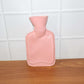 Small hot water bag in use for warm compress and pain comfort