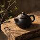 Matte black ceramic tea set arranged for serving guests