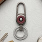 Durable metal key holder with dual rings and locking clip attached to a backpack