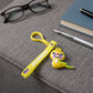 Dinosaur cartoon keychain attached via metal clip to bag zipper