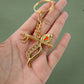 Front view of metal Krishna keychain with intricate peacock feather and flute