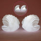 A child's hand reaching for the gentle glow of the Pearl Shell Night Lamp.