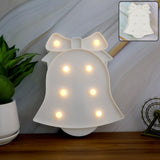 Pink LED Bell Shaped Night Light glowing warmly on wooden table