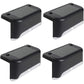Four solar garden lights arranged along a pathway, providing warm ambient lighting.