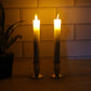 Pair of battery operated flameless LED taper candles glowing warmly during festival celebration