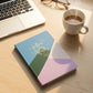 Open pages of hardcover ruled notebook displaying ruled lines and calendar layout