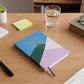 Multiple hardcover ruled notebooks stacked showing compact 21x15 cm size